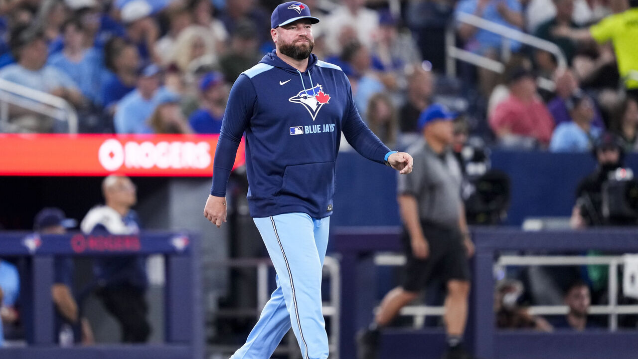 TORONTO, ON - AUGUST 12: John Schneider manager of the Toronto Blue Jays walks to the mound in a break in play against the Chicago Cubs in their MLB game at the Rogers Centre on August 12, 2025 in Toronto, Ontario, Canada.