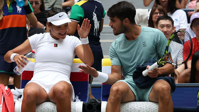 TOPSHOT - Britain's Emma Raducanu and Carlos Alcaraz of Spain chat during a break in their first round mixed doubles match against Jessica Pegula of the US and Jack Draper of Britain at the US Open tennis tournament at the USTA Billie Jean King National Tennis Center in New York City on August 19, 2025.