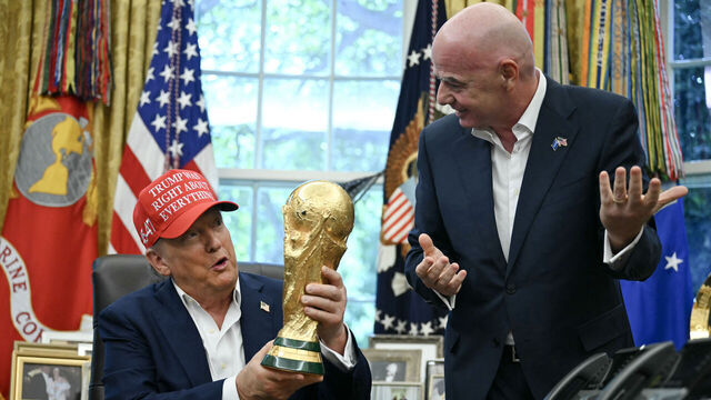 US President Donald Trump joined by FIFA president Gianni Infantino (R) holds the World Cup Trophy as he makes an announcement in the Oval Office of the White House in Washington, DC, on August 22, 2025. Trump announced the 2026 World Cup draw will be held on December 5 at Washington's Kennedy Center.