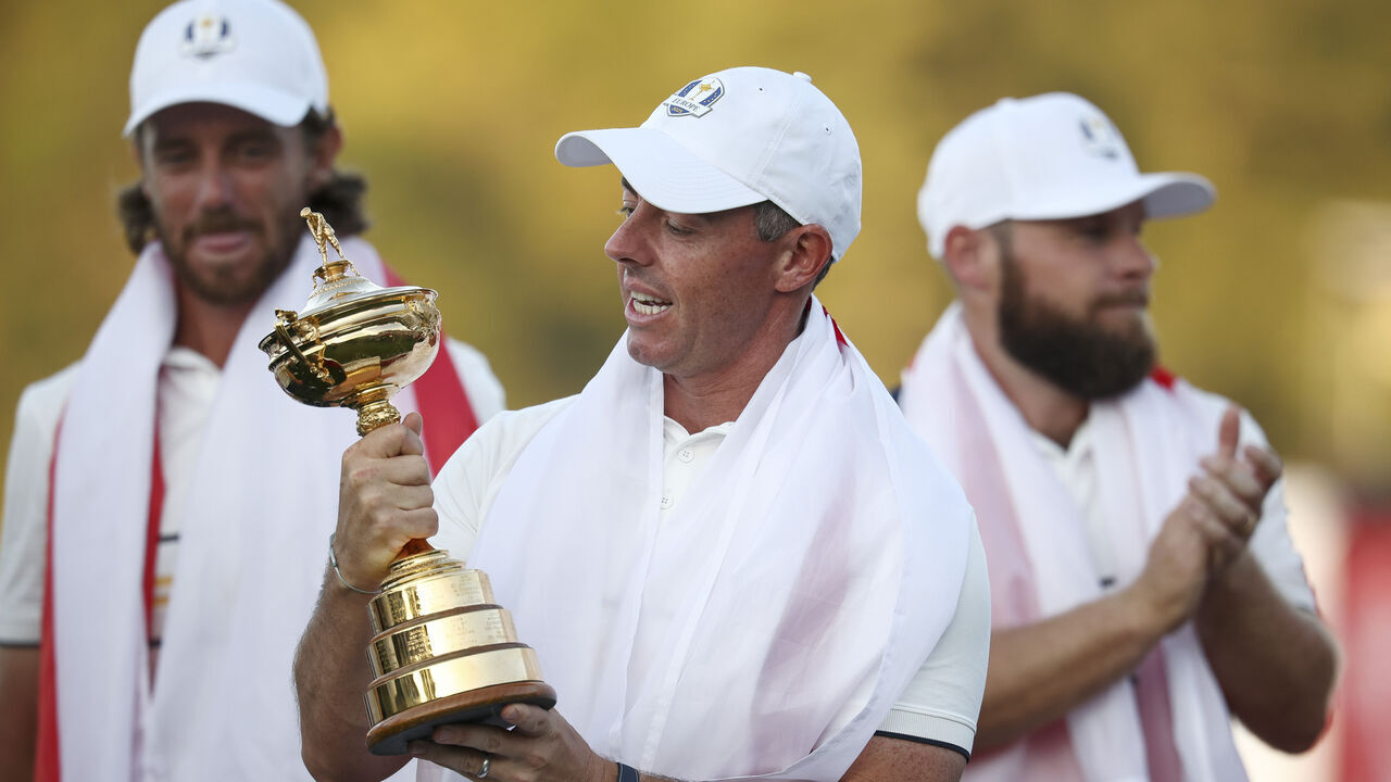 FARMINGDALE, NEW YORK - SEPTEMBER 28: Rory McIlroy of Team Europe holds the Ryder Cup trophy as Team Europe celebrates their 15-13 win over Team United States during the trophy presentation ceremony during the Sunday singles matches of the 2025 Ryder Cup at Black Course at Bethpage State Park Golf Course on September 28, 2025 in Farmingdale, New York.