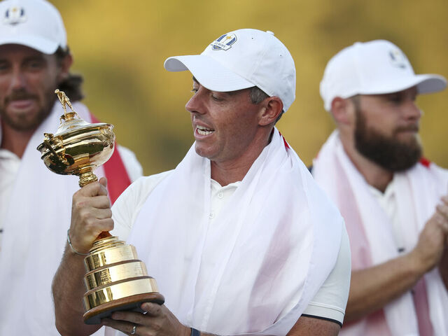 FARMINGDALE, NEW YORK - SEPTEMBER 28: Rory McIlroy of Team Europe holds the Ryder Cup trophy as Team Europe celebrates their 15-13 win over Team United States during the trophy presentation ceremony during the Sunday singles matches of the 2025 Ryder Cup at Black Course at Bethpage State Park Golf Course on September 28, 2025 in Farmingdale, New York.