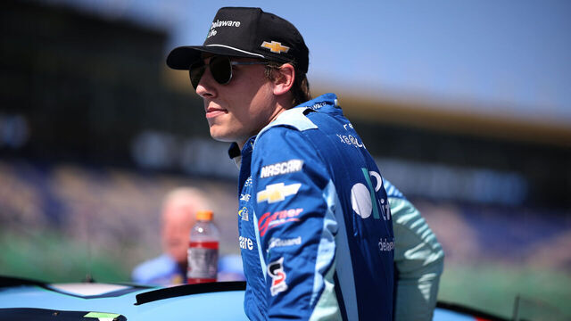 KANSAS CITY, KANSAS - SEPTEMBER 27: Carson Hocevar, driver of the #77 Delaware Life Chevrolet, enters his car during qualifying for the NASCAR Cup Series Hollywood Casino 400 Presented by ESPN BET at Kansas Speedway on September 27, 2025 in Kansas City, Kansas.