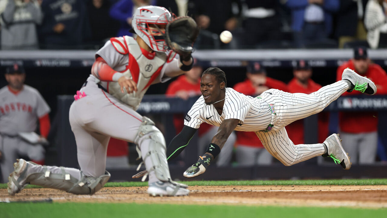 NEW YORK, NEW YORK - OCTOBER 01: Jazz Chisholm Jr. #13 of the New York Yankees dives into home plate to score a go-ahead run during the eighth inning against the Boston Red Sox in game two of the American League Wild Card Series at Yankee Stadium on October 01, 2025 in the Bronx borough of New York City.