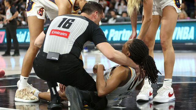 LAS VEGAS, NEVADA - SEPTEMBER 30: Referee Isaac Barnett holds Kelsey Mitchell #0 of the Indiana Fever as Odyssey Sims #1 and Lexie Hull #10 of the Fever look on after Mitchell was hurt in the third quarter of Game Five of the 2025 WNBA Playoffs semifinals against the Las Vegas Aces at Michelob ULTRA Arena Michelob ULTRA Arena on September 30, 2025 in Las Vegas, Nevada.
