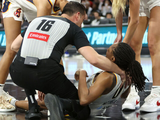 LAS VEGAS, NEVADA - SEPTEMBER 30: Referee Isaac Barnett holds Kelsey Mitchell #0 of the Indiana Fever as Odyssey Sims #1 and Lexie Hull #10 of the Fever look on after Mitchell was hurt in the third quarter of Game Five of the 2025 WNBA Playoffs semifinals against the Las Vegas Aces at Michelob ULTRA Arena Michelob ULTRA Arena on September 30, 2025 in Las Vegas, Nevada.