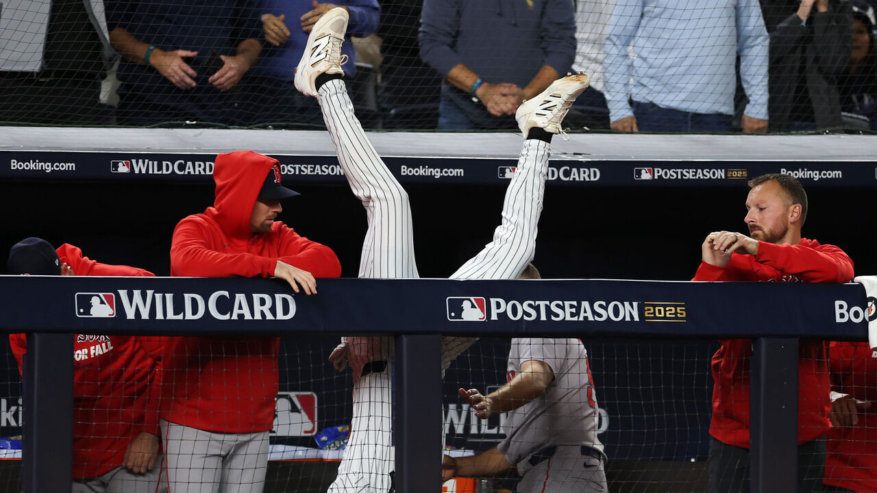 NEW YORK, NEW YORK - OCTOBER 02: Ryan McMahon #19 of the New York Yankees leaps over the dugout wall to catch a pop fly during the eighth inning against the Boston Red Sox in game three of the American League Wild Card Series at Yankee Stadium on October 02, 2025 in the Bronx borough of New York City.
