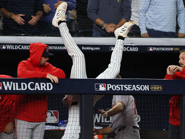 NEW YORK, NEW YORK - OCTOBER 02: Ryan McMahon #19 of the New York Yankees leaps over the dugout wall to catch a pop fly during the eighth inning against the Boston Red Sox in game three of the American League Wild Card Series at Yankee Stadium on October 02, 2025 in the Bronx borough of New York City.