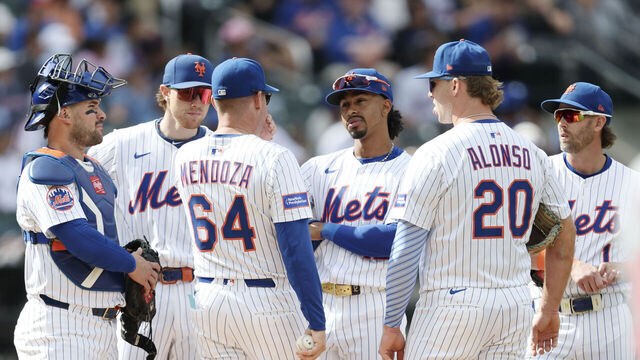 NEW YORK, NEW YORK - SEPTEMBER 21: Manager Carlos Mendoza #64 of the New York Mets meets with his team on the mound after a pitching change during the fourth inning against the Washington Nationals at Citi Field on September 21, 2025 in New York City.