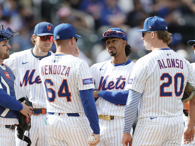 NEW YORK, NEW YORK - SEPTEMBER 21: Manager Carlos Mendoza #64 of the New York Mets meets with his team on the mound after a pitching change during the fourth inning against the Washington Nationals at Citi Field on September 21, 2025 in New York City.