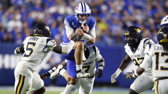 PROVO, UT - OCTOBER 3: Bear Bachmeier #47 of the Brigham Young Cougars rushes the ball against Fred Perry #5, Israel Boyce #7, Adam Tomczyk #97, and Derek Carter Jr., #13 of the West Virginia Mountaineers during the second half their game at LaVell Edwards Stadium on October 3, 2025 at Provo, Utah.