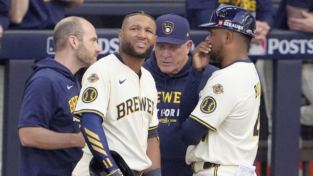 MILWAUKEE, WISCONSIN - OCTOBER 04: Jackson Chourio #11 of the Milwaukee Brewers reacts as he is checked on by the trainer and Manager Pat Murphy #49 against the Chicago Cubs during the second inning in game one of the Division Series at American Family Field on October 04, 2025 in Milwaukee, Wisconsin.