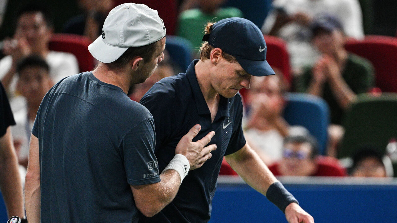 TOPSHOT - Italy's Jannik Sinner (R) reacts as he retires from his men's singles match against Netherlands' Tallon Griekspoor (L) at the Shanghai Masters tennis tournament in Shanghai on October 6, 2025.