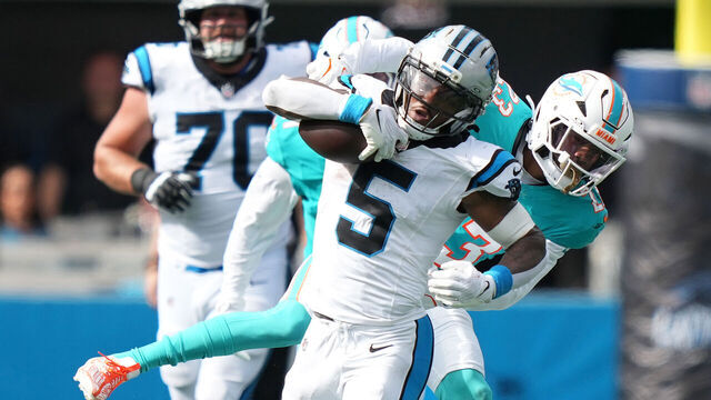 CHARLOTTE, NORTH CAROLINA - OCTOBER 05: Rico Dowdle #5 of the Carolina Panthers breaks a tackle by Jack Jones #23 of the Miami Dolphins during the fourth quarter in the game at Bank of America Stadium on October 05, 2025 in Charlotte, North Carolina.