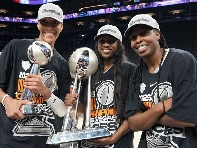 PHOENIX, AZ - OCTOBER 10: A'ja Wilson #22, Jackie Young #0, and Chelsea Gray #12 of the Las Vegas Aces pose for a photo with the 2025 WNBA Championship trophy after winning the game against the Phoenix Mercury on October 10, 2025 at PHX Arena in Phoenix, Arizona. Mandatory Copyright Notice: Copyright 2025 NBAE