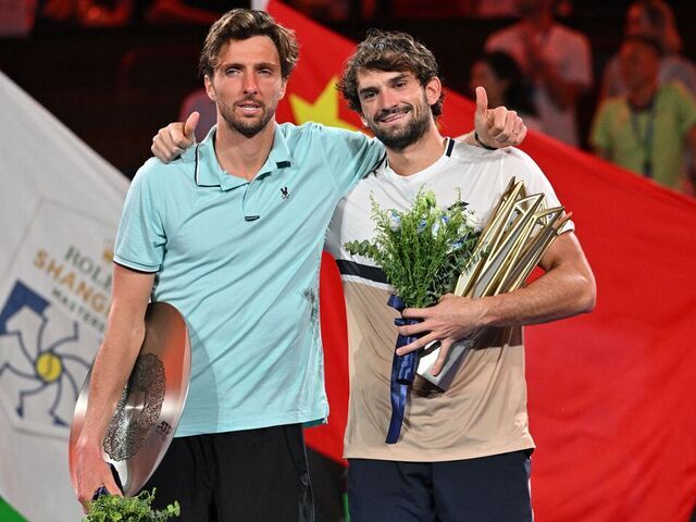 Monaco's Valentin Vacherot (R) poses with the trophy after his victory against France's Arthur Rinderknech (L) during the men's singles final at the Shanghai Masters tennis tournament in Shanghai on October 12, 2025.