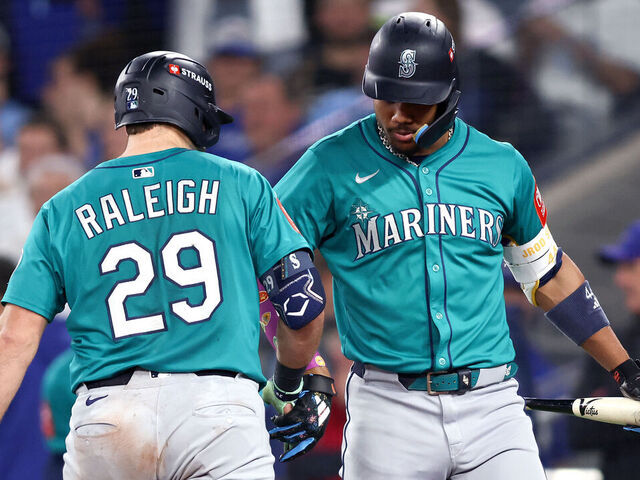 TORONTO, ONTARIO - OCTOBER 12: Cal Raleigh #29 of the Seattle Mariners celebrates with Julio Rodriguez #44 after hitting a solo home run against the Toronto Blue Jays during the sixth inning in game one of the American League Championship Series at Rogers Centre on October 12, 2025 in Toronto, Ontario.