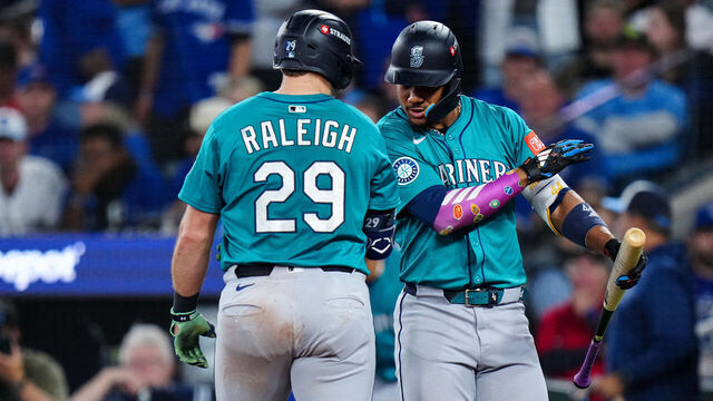 TORONTO, ON - OCTOBER 12: Cal Raleigh #29 and Julio Rodriguez #44 of the Seattle Mariners celebrate after Raleigh's solo home run in the sixth inning of Game One of the American League Championship Series presented by loanDepot between the Seattle Mariners and the Toronto Blue Jays at Rogers Centre on Sunday, October 12, 2025 in Toronto, Ontario, Canada.