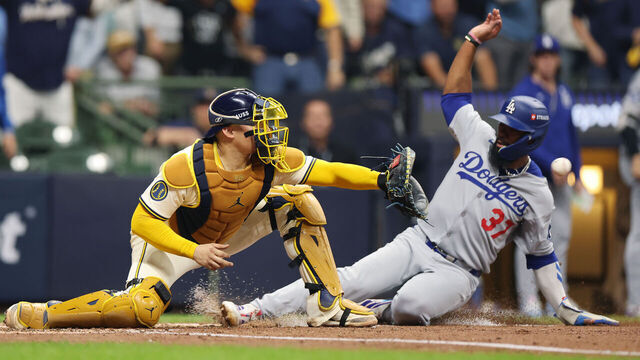 MILWAUKEE, WISCONSIN - OCTOBER 13: William Contreras #24 of the Milwaukee Brewers forces out at Teoscar Hernández #37 of the Los Angeles Dodgers at home plate during the fourth inning in game one of the National League Championship Series at American Family Field on October 13, 2025 in Milwaukee, Wisconsin.