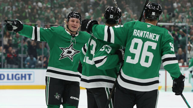 DALLAS, TEXAS - OCTOBER 14: Esa Lindell #23 of the Dallas Stars is congratulated by Roope Hintz #24 and Mikko Rantanen #96 after scoring a goal during the first period against the Minnesota Wild at American Airlines Center on October 14, 2025 in Dallas, Texas.