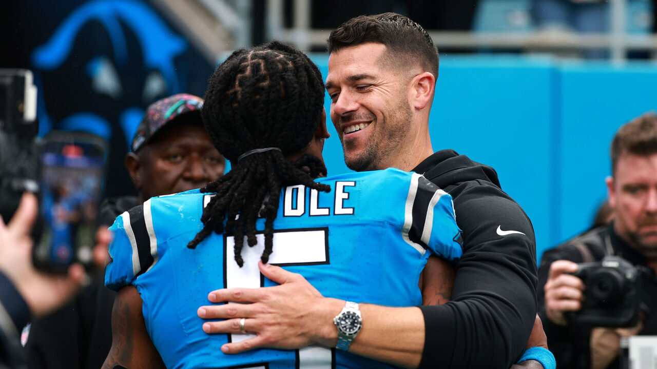 CHARLOTTE, NORTH CAROLINA - OCTOBER 12: Rico Dowdle #5 and head coach Dave Canales of the Carolina Panthers hug after the game against the Dallas Cowboys at Bank of America Stadium on October 12, 2025 in Charlotte, North Carolina.