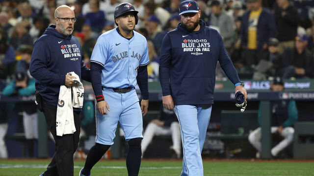 SEATTLE, WASHINGTON - OCTOBER 17: George Springer #4 of the Toronto Blue Jays (C) exits the game after being hit on the knee by a pitch during the seventh inning against the Seattle Mariners in game five of the American League Championship Series at T-Mobile Park on October 17, 2025 in Seattle, Washington.