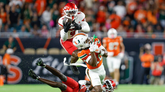MIAMI GARDENS, FL - OCTOBER 17: Defensive back Antonio Watts (9) of the Louisville Cardinals makes an interception in front of Wide receiver Malachi Toney (10) of the Miami Hurricanes in a game between the Miami Hurricanes and the Louisville Cardinals on October 17, 2025, at Hard Rock Stadium in Miami Gardens, FL.