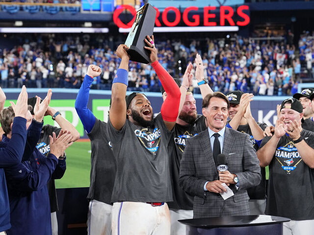 TORONTO, ONTARIO - OCTOBER 20: Vladimir Guerrero Jr. #27 of the Toronto Blue Jays lifts the William Harridge Trophy after winning game seven of the American League Championship Series against the Seattle Mariners at the Rogers Centre on October 20, 2025 in Toronto, Ontario.