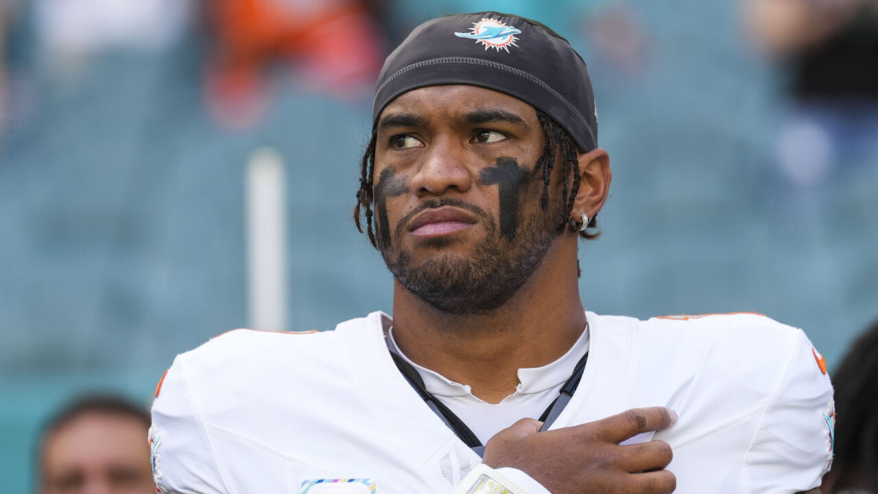 MIAMI GARDENS, FLORIDA - OCTOBER 12: Tua Tagovailoa #1 of the Miami Dolphins looks on from the sideline during the national anthem prior to an NFL football game against the Los Angeles Chargers at Hard Rock Stadium on October 12, 2025 in Miami Gardens, Florida.