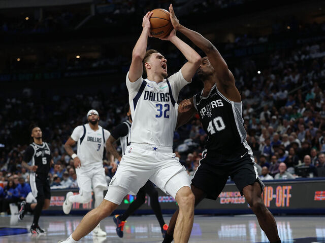 DALLAS, TEXAS - OCTOBER 22: Cooper Flagg #32 of the Dallas Mavericks drives to the basket against Harrison Barnes #40 of the San Antonio Spurs during the second half at American Airlines Center on October 22, 2025 in Dallas, Texas.