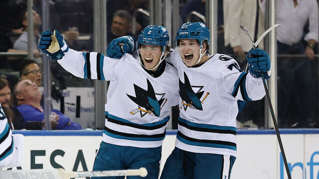NEW YORK, NEW YORK - OCTOBER 23: Will Smith #2 and Macklin Celebrini #71 of the San Jose Sharks celebrate with Alex Nedeljkovic #33 after Smith scored the game-winning goal in overtime against the New York Rangers at Madison Square Garden on October 23, 2025 in New York City. The Sharks won 6-5.