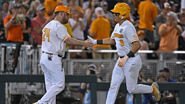 OMAHA, NE - JUNE 22: Hunter Ensley #9 of the Tennessee Volunteers celebrates with third base coach Josh Elander #24 after hitting a solo home run in the seventh inning against the Texas A&M Aggies during the NCAA Division I Baseball Championship on June 22, 2024 at Charles Schwab Field in Omaha, Nebraska.
