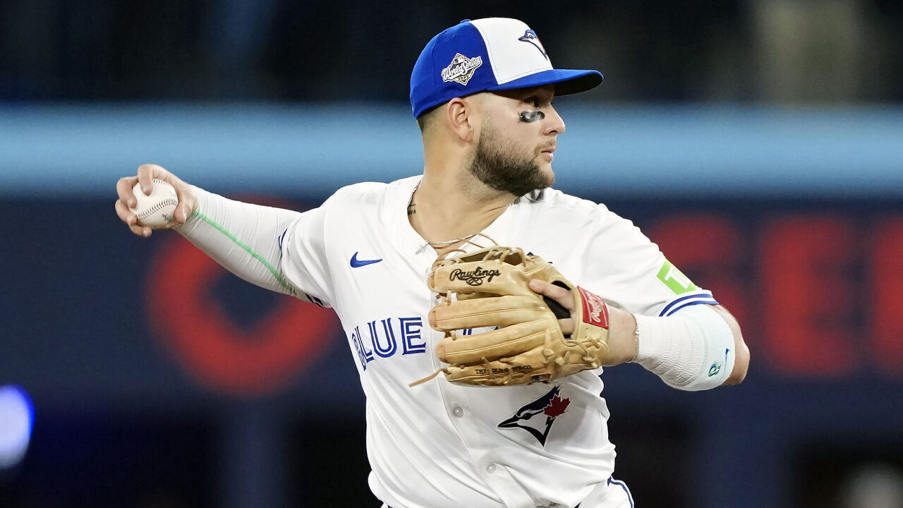 TORONTO, ONTARIO - OCTOBER 24: Bo Bichette #11 of the Toronto Blue Jays throws to first base late after forcing out Will Smith #16 of the Los Angeles Dodgers at second base in game one of the 2025 World Series at Rogers Center on October 24, 2025 in Toronto, Ontario.