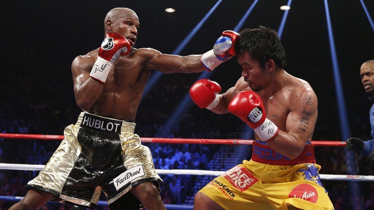 Floyd Mayweather Jr. exchange punches with Manny Pacquiao during their welterweight unification championship bout, May 2, 2015 at MGM Grand Garden Arena in Las Vegas, Nevada. Mayweather defeated Pacquiao by unanimous decision. AFP PHOTO / JOHN GURZINKSI