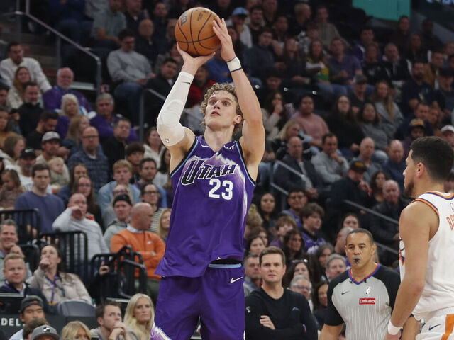 SALT LAKE CITY, UT - OCTOBER 27: Lauri Markkanen #23 of the Utah Jazz shoots a three pointer over Devin Booker #1 of the Phoenix Suns during the first half of their game at the Delta Center on October 27, 2025 in Salt Lake City, Utah.