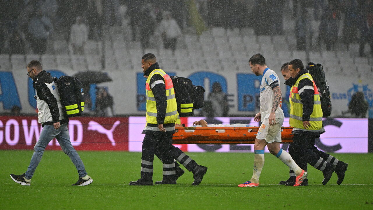 Marseille's French midfielder #26 Bilal Nadir is evacuated after collapsing escorted by Marseille's Danish midfielder captain #23 Pierre-Emile Hojbjerg during the French L1 football match between Olympique de Marseille (OM) and SCO Angers at the Velodrome stadium in Marseille, southern France, on October 29, 2025.