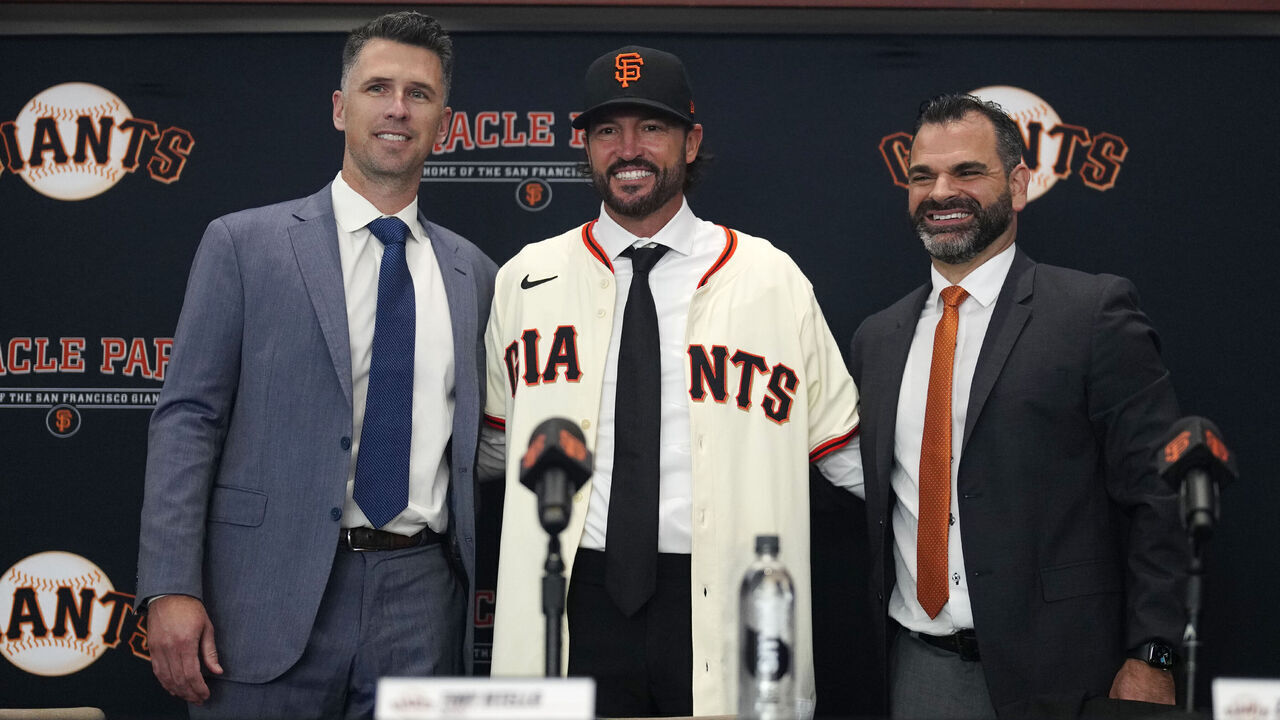SAN FRANCISCO, CALIFORNIA- OCTOBER 30: Buster Posey, Tony Vitello #23 and Zack Minasian of the San Francisco Giants present a hat and jersey during a press conference to introduce Vitello as the new manager at Oracle Park on October 30, 2025 in San Francisco, California.