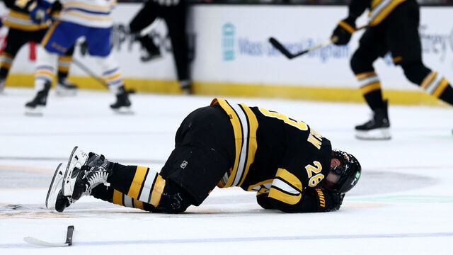 BOSTON, MASSACHUSETTS - OCTOBER 30: Elias Lindholm #28 of the Boston Bruins falls to the ground due to injury during the second period of the game against the Buffalo Sabres at TD Garden on October 30, 2025 in Boston, Massachusetts.