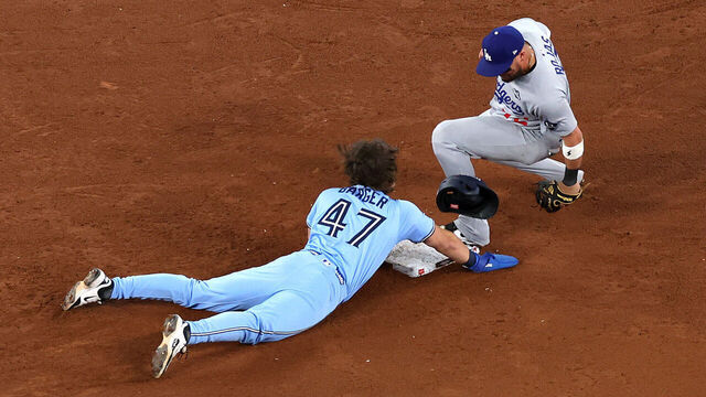 TORONTO, ONTARIO - OCTOBER 31: Miguel Rojas #72 of the Los Angeles Dodgers forces out Addison Barger #47 of the Toronto Blue Jays to win the game 3-1 in game six of the 2025 World Series at Rogers Center on October 31, 2025 in Toronto, Ontario.
