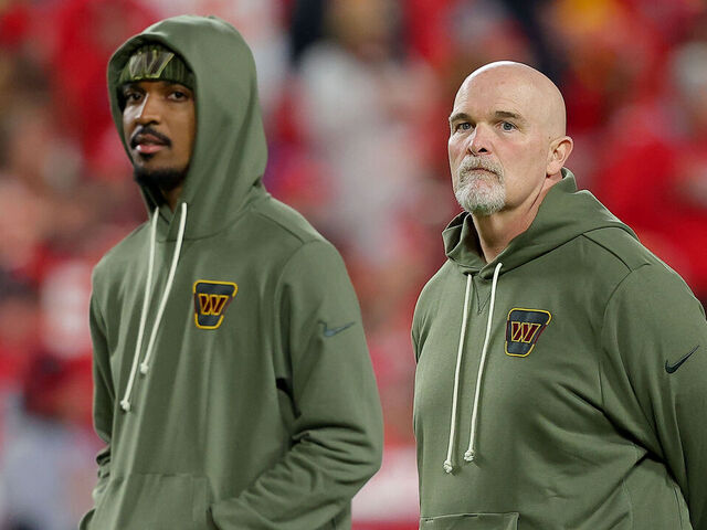 KANSAS CITY, MISSOURI - OCTOBER 27: (L-R) Jayden Daniels #5 and head coach Dan Quinn of the Washington Commanders talk prior to the game against the Kansas City Chiefs at Arrowhead Stadium on October 27, 2025 in Kansas City, Missouri.