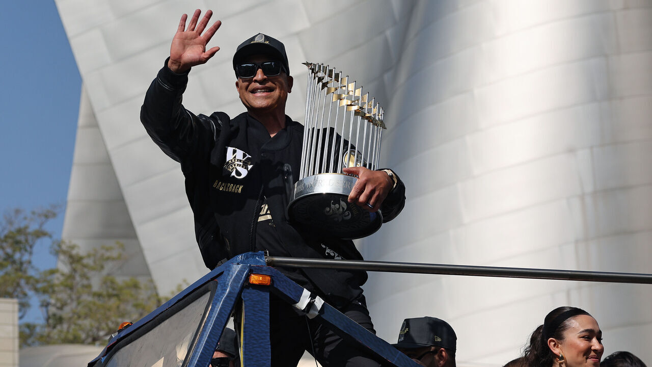 LOS ANGELES, CALIFORNIA - NOVEMBER 03: Manager Dave Roberts of the Los Angeles Dodgers celebrates on a bus with the Commissioner's Trophy during the Dodgers 2025 World Series Championship parade on November 03, 2025 in Los Angeles, California.