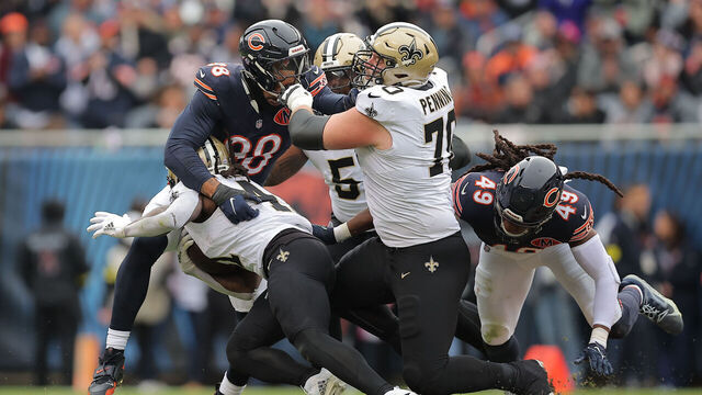 CHICAGO, IL - OCTOBER 19: Montez Sweat #98 of the Chicago Bears tackles Alvin Kamara #41 of the New Orleans Saints while holding Trevor Penning #70 of the New Orleans Saints during the second half on October 19, 2025 at Soldier Field in Chicago, Illinois.