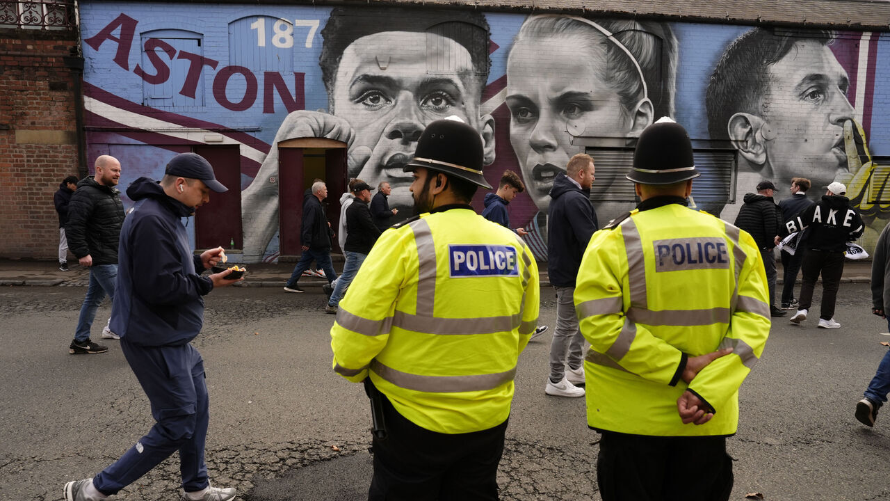 Police officers look on as Aston Villa fans walk past a mural of Aston Villa's players Ollie Watkins, Rachel Daly and goalkeeper Emiliano Martinez before the Premier League match at Villa Park, Birmingham. Picture date: Saturday April 19, 2025.