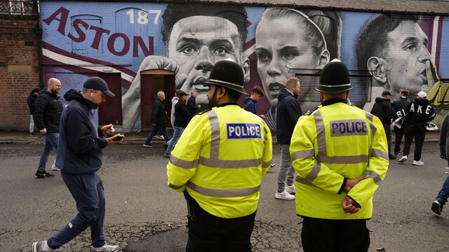 Police officers look on as Aston Villa fans walk past a mural of Aston Villa's players Ollie Watkins, Rachel Daly and goalkeeper Emiliano Martinez before the Premier League match at Villa Park, Birmingham. Picture date: Saturday April 19, 2025.