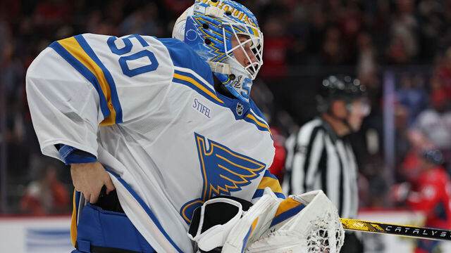 WASHINGTON, DC - NOVEMBER 05: Goalie Jordan Binnington #50 of the St. Louis Blues attempts to hide the puck in his pads of NHL career goal 900 by Alex Ovechkin #8 of the Washington Capitals (not pictured) during the second period at Capital One Arena on November 5, 2025 in Washington, DC.