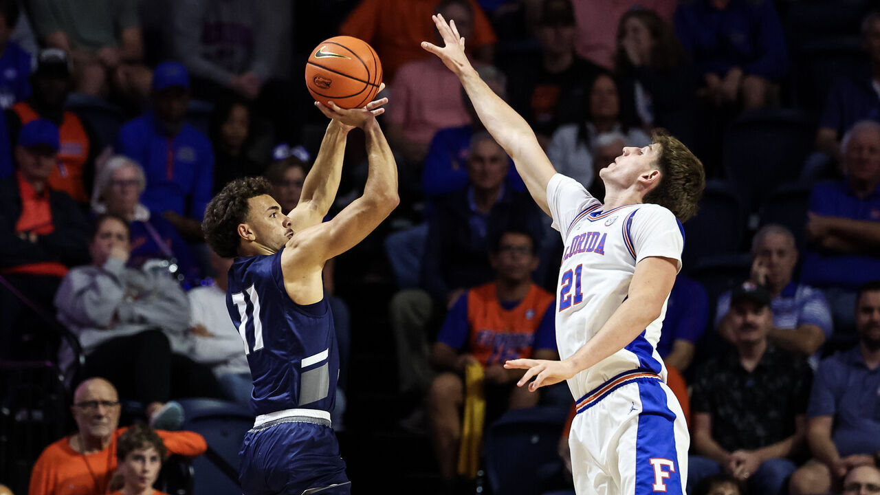 GAINESVILLE, FLORIDA - NOVEMBER 06: Kamrin Oriol #11 of the North Florida Ospreys shoots the ball against Alex Condon #21 of the Florida Gators during the first half of a game at the Stephen C. O'Connell Center on November 06, 2025 in Gainesville, Florida.