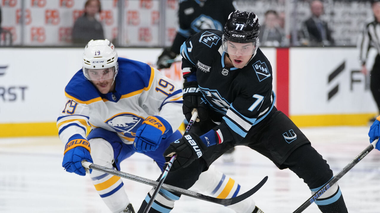 SALT LAKE CITY, UTAH - NOVEMBER 12: JJ Peterka #77 of the Utah Mammoth skates with the puck as Peyton Krebs #19 and Beck Malenstyn #29 of the Buffalo Sabres defend in the third period of a game at Delta Center on November 12, 2025 in Salt Lake City, Utah.