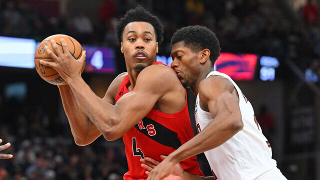 CLEVELAND, OHIO - NOVEMBER 13: Forward Scottie Barnes #4 of the Toronto Raptors drives to the basket around forward De'Andre Hunter #12 of the Cleveland Cavaliers during the fourth quarter at Rocket Arena on November 13, 2025 in Cleveland, Ohio. The Raptors defeated the Cavaliers 126-113.