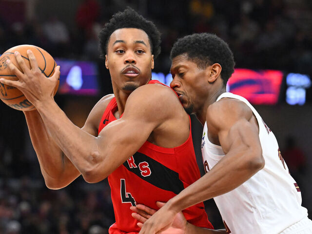 CLEVELAND, OHIO - NOVEMBER 13: Forward Scottie Barnes #4 of the Toronto Raptors drives to the basket around forward De'Andre Hunter #12 of the Cleveland Cavaliers during the fourth quarter at Rocket Arena on November 13, 2025 in Cleveland, Ohio. The Raptors defeated the Cavaliers 126-113.