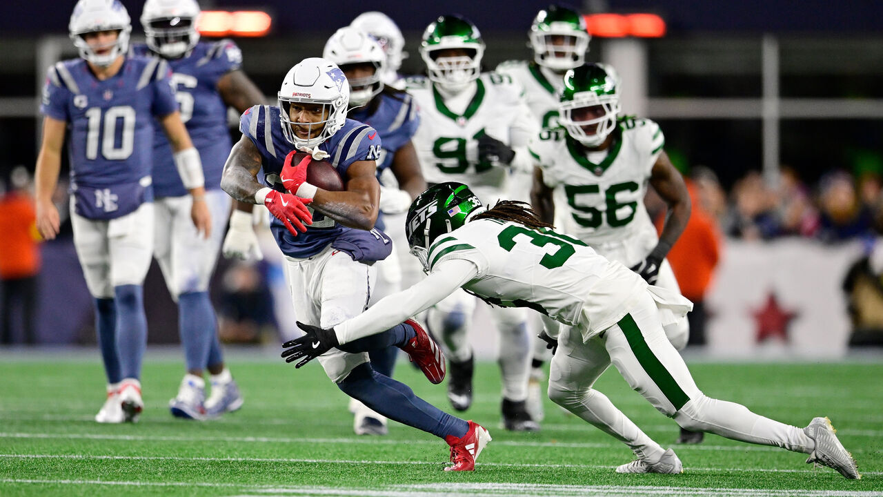 FOXBOROUGH, MASSACHUSETTS - NOVEMBER 13: TreVeyon Henderson #32 of the New England Patriots is pursued by Ja'Sir Taylor #36 of the New York Jets during the first half at Gillette Stadium on November 13, 2025 in Foxborough, Massachusetts.