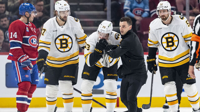 MONTREAL, CANADA- NOVEMBER 15: Charlie McAvoy #73 of the Boston Bruins exits the ice with a medical staff after being hit to the face by a puck during the second period of the NHL regular season game between the Montreal Canadiens and the Boston Bruins at the Bell Centre on November 15, 2025 in Montreal, Quebec, Canada.